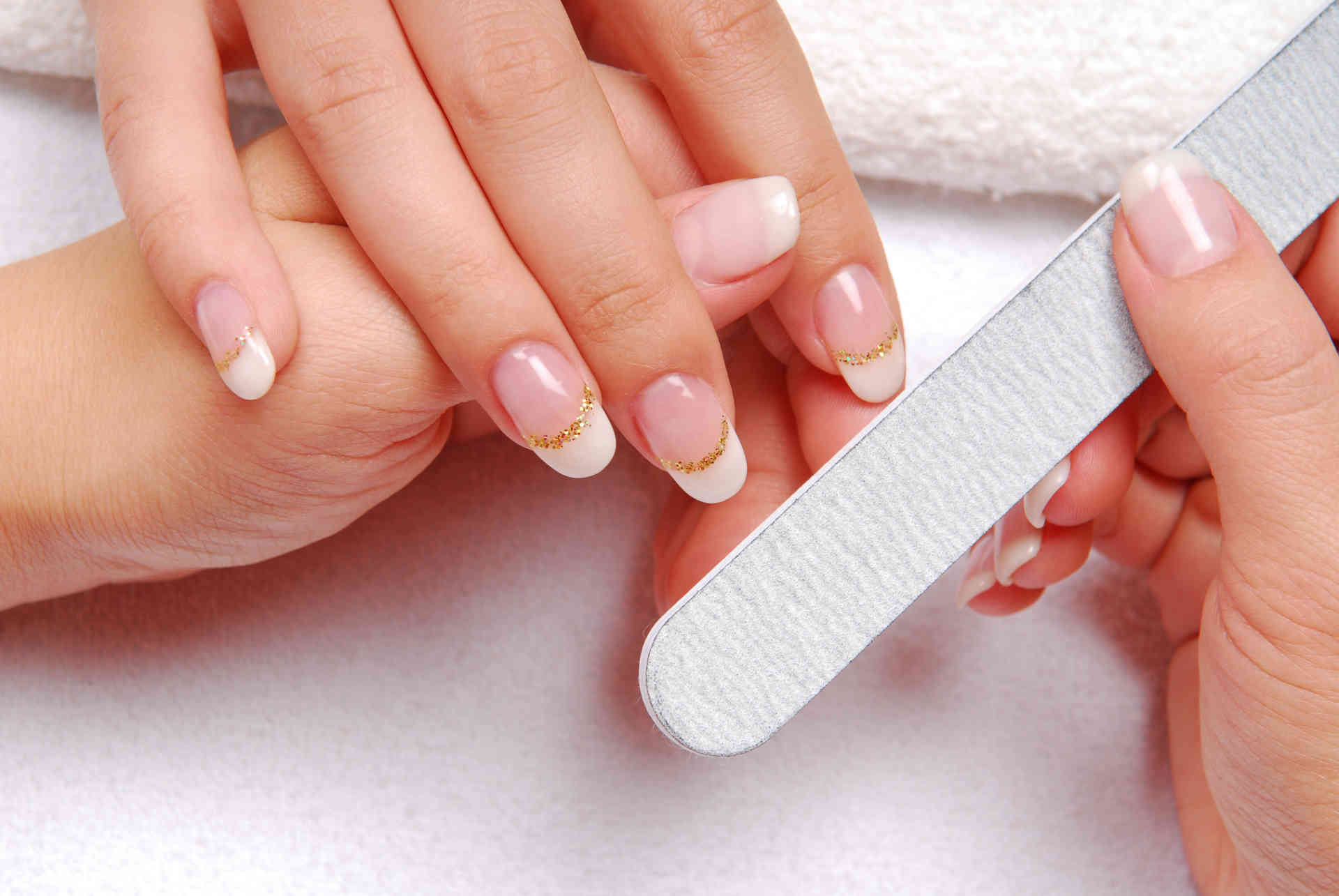 beautician polishing female nails.